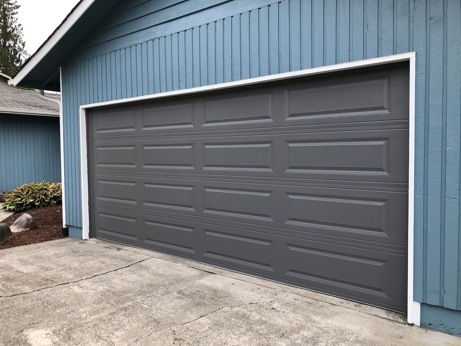 Black garage door on a blue home